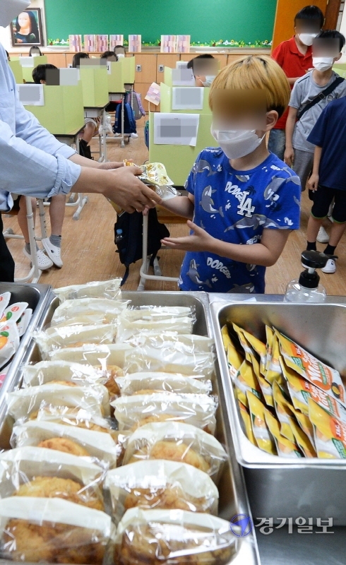 인천시 서구 이외에 부평, 강화군 지역에서도 수돗물 유충 신고가 접수돼 상수도 당국이 확인하고 있는 가운데 15일 서구의 한 초등학교 교사가 학생들에게  빵을 비롯한 대체급식을 나눠주고 있다. 장용준기자
