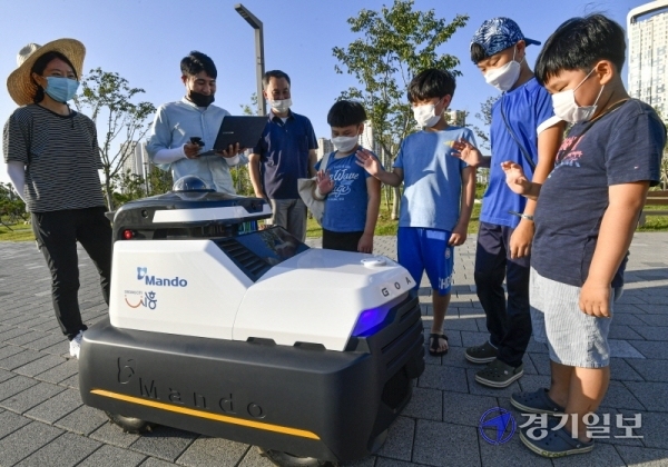 자율주행 순찰로봇 ‘골리’가 15일 오후 시흥시 배곧신도시 생명공원에서 만도 운곡캠퍼스 F3Lab 로봇플랫폼팀 관계자들과 시험운행을 하고 있다. ‘골리‘는 시험운행 기간동안 빅데이터 기술을 활용, 새로운 비전알고리즘을 통해 사물 환경 인식 수준을 높인 뒤 이르면 오는 9월부터 야간 순찰로봇으로서의 임무를 수행할 계획이다. 조주현기자