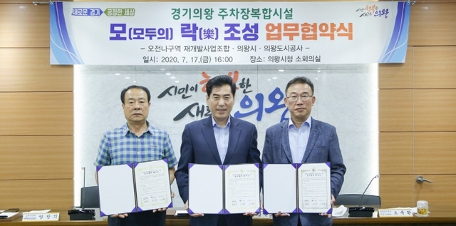 최근 의왕시청 소회의실에서 열린 ‘모(모두의) 락(樂)’ 조성사업 업무협약 체결식에서 김상돈 의왕시장(사진 가운데)이 양창의 오전 ‘나’구역 재개발사업조합장(왼쪽)과 오복환 의왕도시공사 사장직무대행과 기념촬영을 하고 있다. 의왕시 제공