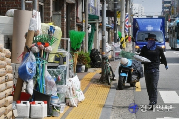 21일 오후 수원시 장안구 정자동 인도에 주변 상점들이 물건들을 적치해 놓고 있어 행인들이 통행에 큰 불편을 겪고 있다. 김시범기자