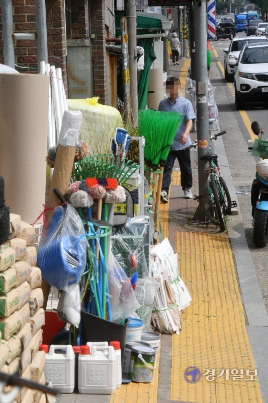 21일 오후 수원시 장안구 정자동 인도에 주변 상점들이 물건들을 적치해 놓고 있어 행인들이 통행에 큰 불편을 겪고 있다. 김시범기자