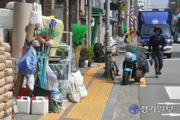 21일 오후 수원시 장안구 정자동 인도에 주변 상점들이 물건들을 적치해 놓고 있어 행인들이 통행에 큰 불편을 겪고 있다. 김시범기자