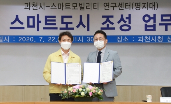 22일 과천시청 상황실에서 열린 과천시와 명지대 스마트모빌리티 연구센터와의 스마트도시 구현을 위한 업무협약에서 김종천 과천시장(왼쪽)이 김현명 스마트모빌리티 연구센터장과 기념촬영을 하고 있다. 과천시 제공