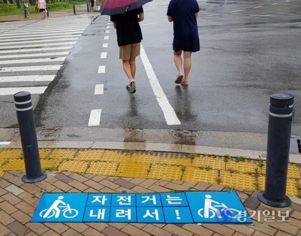 27일 수원시 권선구 금곡로 102번길 사거리에 설치된 ‘자전거횡단도’ 앞에 자전거에서 내린 뒤 걸어가라고 안내하는 내용이 담긴 사인블록(Sign block)이 설치돼 있다. 채태병기자