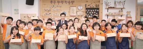 김상돈 의왕시장이 의왕 바라산휴양림에서 진행하고 있는 목공체험학습장을 방문해 학생들과 기념촬영을 하고 있다.