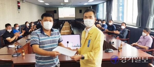 최근 여주시청 4층 대회의실에서 이명호 북내면발전협의회장이 천연가스발전소 송전선로 지상화에 동의하는 19개 마을 이장과 사회단체를 대표해 찬성한 서명서를 이항진 여주시장에게 전달하고 있다. 류진동기자