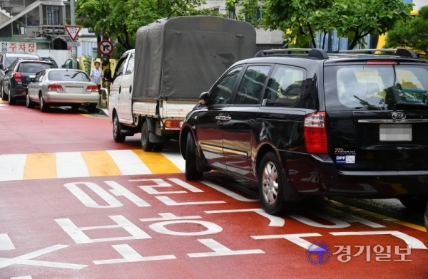 2일 오후 수원시 장안구 송죽동 한 어린이 보호구역에 차량들이 불법 주차돼 있다.  '어린이 보호구역 내 불법 주정차 주민신고제'의 계도기간이 이날 종료되면서 3일부터 주민이 신고한 어린이보호구역 내 불법 주정차 차량에는 과태료 8만원이 부과된다. 김시범기자