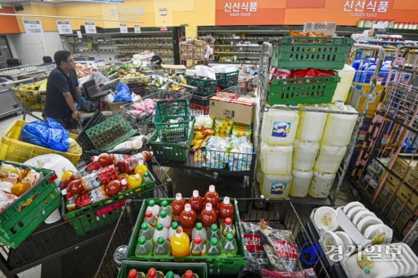 5일 오전 폭우로 침수 피해가 발생한 안성시 죽산면 죽산리 하모니마트 죽산점에서 상인 이창문(53)씨가 물에 젖은 물건들을 애처롭게 바라보고 있다.조주현기자