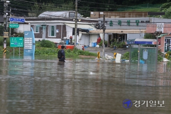 6일 오전 임진강 인근의 파주시 파평면 율곡1리에서 한 시민이 집중호우로 고립된 마을을 건너고 있다. 조주현기자