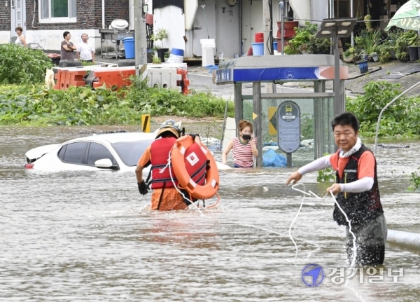 6일 오전 임진강 인근의 파주시 파평면 율곡1리에서 한 주민이 차량을 타고 마을을 건너던 중 고립돼 구조대원에게 구조되고 있다. 조주현기자