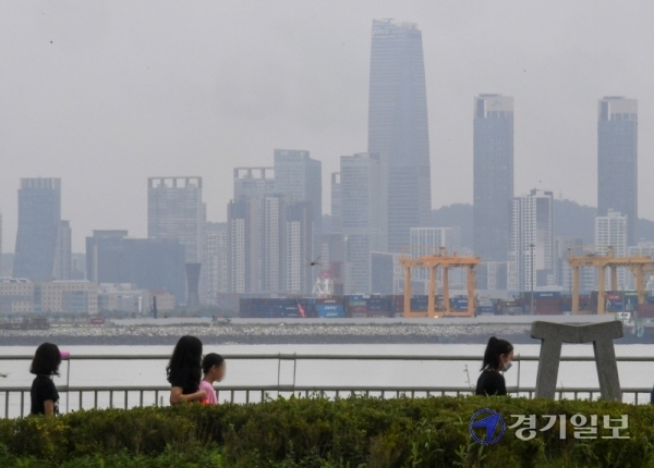 장맛비가 그친 10일 오전 안산 시화방조제를 찾은 나들이객들이  인천 송도국제도시가 보이는 산책길을 걷고 있다. 장용준기자