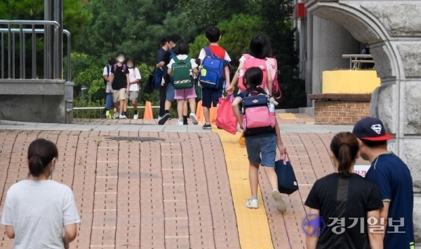 인천을 비롯한 수도권지역의 학교 밀집도 최소화 조치를 시작한 18일 오전 서구 초은 초등학교 교문에서 학부모들이 개학 등교에 나선 자녀들을 지켜보고 있다.이날 학교는 홀수학년에 홀수번호 학생들만 등교시켜 선제적인 1/4 밀집도 최소화 조치를 시행했다. 장용준기자