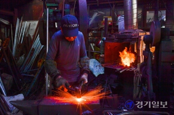 전국 대부분 폭염특보가 내려진 20일 오전 수언시 팔달구 제일대장간에서 대장장이 천재동씨가 쇠를 녹이는 섭씨 2천도 화덕의 열기를 견뎌내며 쇳덩이에 망치질을 하고 있다. 윤원규기자
