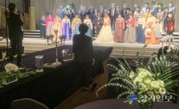 코로나19 확산으로 사회적 거리두기 단계가 전국적으로 2단계로 격상된 23일 오후 도내 한 결혼식장에서 신랑, 신부와 하객들이 마스크를 착용한 채 기념촬영을 하고 있다.조주현기자