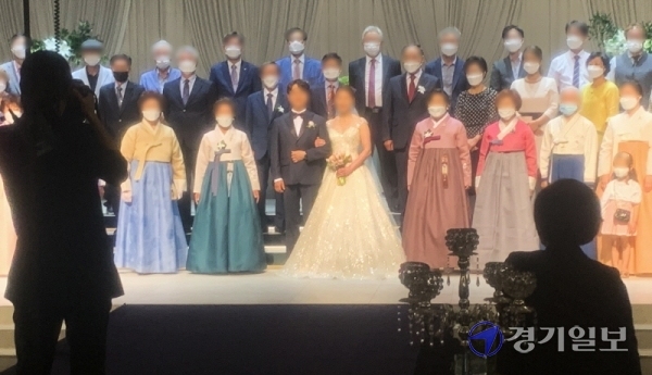 코로나19 확산으로 사회적 거리두기 단계가 전국적으로 2단계로 격상된 23일 오후 도내 한 결혼식장에서 신랑, 신부와 하객들이 마스크를 착용한 채 기념촬영을 하고 있다.조주현기자
