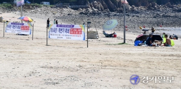 사회적 거리두기 2단계 시행으로 조기 폐장한 인천시 중구 영종도 왕산해수욕장이 첫 주말을 맞은 23일 오후 안내 현수막을 무시한 채 나들이객들이 파라솔과 돗자리를 깔고 음주를 하고 있다. 장용준기자