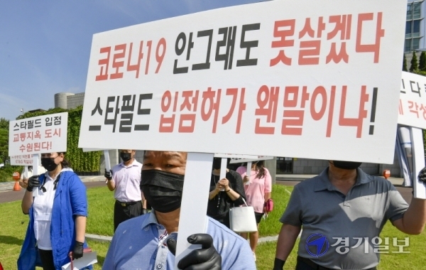 수원시 소상공인연합회 회원들이 25일 오후 시청 정문에서 '스타필드수원'의 건축심의 규탄 및 건축반대 기자회견을 갖고 있다. 조주현기자