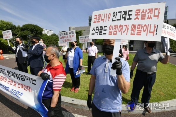 수원시 소상공인연합회 회원들이 25일 오후 시청 정문에서 '스타필드수원'의 건축심의 규탄 및 건축반대 기자회견을 갖고 있다. 조주현기자