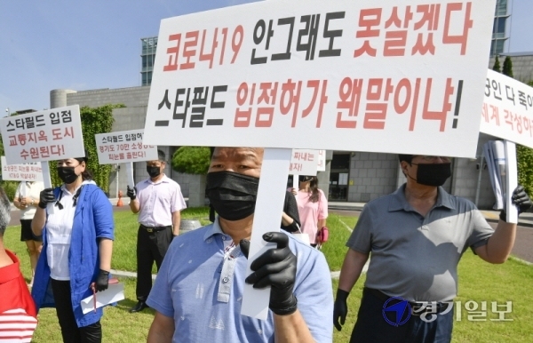수원시 소상공인연합회 회원들이 25일 오후 시청 정문에서 '스타필드수원'의 건축심의 규탄 및 건축반대 기자회견을 갖고 있다. 조주현기자