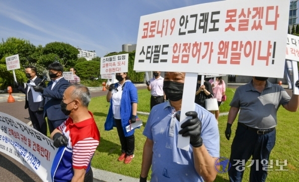 수원시 소상공인연합회 회원들이 25일 오후 시청 정문에서 '스타필드수원'의 건축심의 규탄 및 건축반대 기자회견을 갖고 있다. 조주현기자