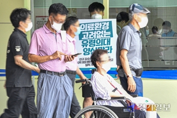 의료계 집단휴진이 계속된 31일 오후 수원시 한 종합병원에서 피켓시위 중인 전공의 앞으로 환자들이 지나가고 있다.  조주현기자
