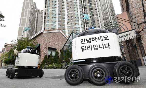 코로나19 사태 속에 등장한 음식배달 로봇이 큰 인기를 끌고 있다. 31일 오후 수원시 앨리웨이 광교에서 실외 자율주행 배달 로봇인 ‘딜리드라이브’가 배달한 음식을 고객이 수령하고 있다