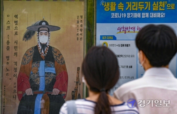 수원시의 코로나19 예방을 위한 마스크 착용 캠페인이 번뜩이는 아이디어로 시민들의 호응을 얻고 있다. 5일 오후 수원시청 앞 게시판에 마스크를 쓴 정조대왕의 어진이 걸려 있다. 시는 마스크 '마스크가 답이다' 캠페인을 지난 6월부터 전개하고 있다. 조주현기자