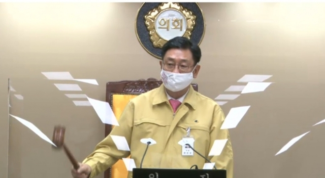 ▲ 전진선 양평군의회 의장이 비말차단용 가리막이 설치된 의장석에서 재난안전복을 착용하고 회의를 주재하고 있다