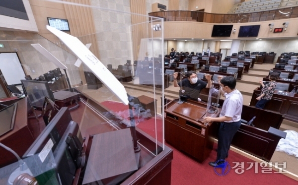 7일 오전 제265회 인천시의회 임시회 1차 본회의를 하루 앞두고 본회의장에서 의회 관계자들이 비말 차단용 칸막이를 설치하고 있다. 장용준기자