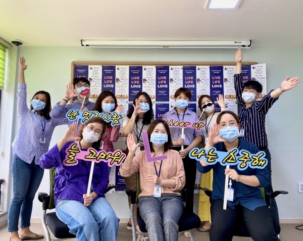 자살예방팀원들이 L챌린지 포스터 앞에서 캠페인 포즈를 취하고 있다.