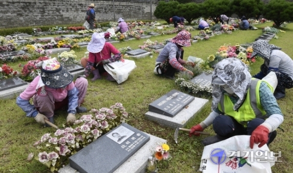 10일 오후 용인 평온의숲 야외묘지에서 관계자들이 벌초를 하고 있다. 한편 경기지역 시립봉안시설들은 코로나19 예방을 위해 추석 연휴동안 운영을 중단하거나 참배 인원을 제한하기로 했다. 조주현기자