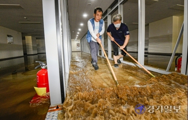 15일 오전 5시 30분께 성남종합운동장 사거리 일대가 지하 상수도관 파열로 물바다로 변한 가운데 침수 피해를 입은 한 상점에서 직원들이 배수 및 복구작업을 하고 있다. 이 사고로 오전 한때 차량 운행이 전면 통제되고 주택과 건물 등 1천여 세대의 수돗물 공급이 중단됐다. 조주현기자