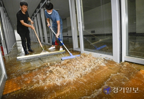15일 오전 5시 30분께 성남종합운동장 사거리 일대가 지하 상수도관 파열로 물바다로 변한 가운데 침수 피해를 입은 한 상점에서 직원들이 배수 및 복구작업을 하고 있다. 이 사고로 오전 한때 차량 운행이 전면 통제되고 주택과 건물 등 1천여 세대의 수돗물 공급이 중단됐다. 조주현기자