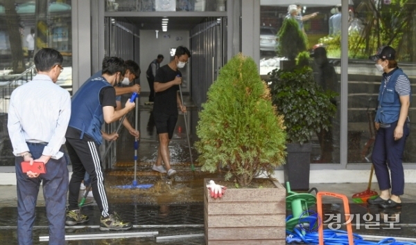15일 오전 5시 30분께 성남종합운동장 사거리 일대가 지하 상수도관 파열로 물바다로 변한 가운데 침수 피해를 입은 한 상점에서 직원들이 배수 및 복구작업을 하고 있다. 이 사고로 오전 한때 차량 운행이 전면 통제되고 주택과 건물 등 1천여 세대의 수돗물 공급이 중단됐다. 조주현기자