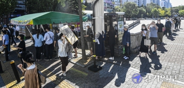 코로나19 장기화로 불황이 계속되는 가운데 19일 오후 고양시 일산동구 한 복권판매점에 일확천금을 꿈꾸는 시민들로 긴 줄이 늘어서 있다. 올 상반기 복권은 2조6천억원어치 팔려나가 2005년 이후 최대 규모의 판매를 기록한 것으로 나타났다.조주현기자