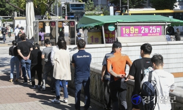 코로나19 장기화로 불황이 계속되는 가운데 19일 오후 고양시 일산동구 한 복권판매점에 일확천금을 꿈꾸는 시민들로 긴 줄이 늘어서 있다. 올 상반기 복권은 2조6천억원어치 팔려나가 2005년 이후 최대 규모의 판매를 기록한 것으로 나타났다.조주현기자