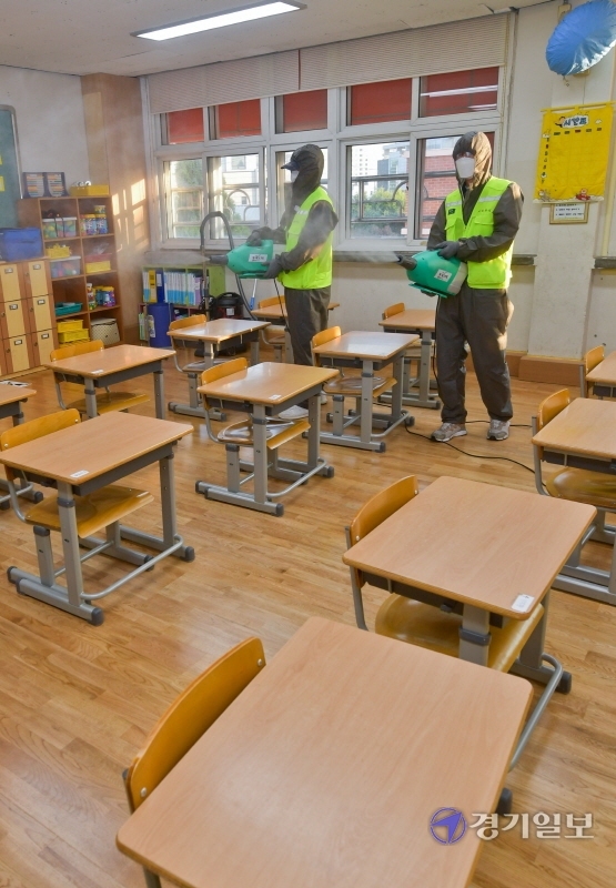 경기도내 유치원, 초ㆍ중ㆍ고교 등교 재개를 하루 앞둔 20일 오후 수원 영화초등학교 교실에서 방역관계자들이 소독을 하고 있다. 한편 다음 달 11일까지는 각 학교별로 등교인원이 제한돼, 원격 수업과 병행된다. 윤원규기자