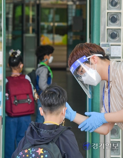 코로나19로 통제됐던 수도권 지역 유·초·중·고 학생들의 등교가 한달여만에 재개된 21일 오전 수원 원일초등학교 학생들이 등교하며 발열체크를 하고 있다. 윤원규기자