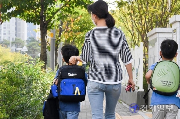 인천을 비롯한 수도권 지역의 유·초·중·고 학생들의 등교가 한달여만에 이뤄진 21일 오전 서구의 한 초등학교 1학년 학부모가 책가방을 들어주고 있다. 장용준 기자