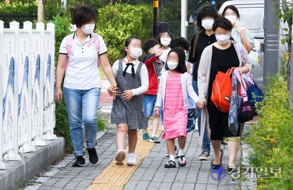 인천을 비롯한 수도권 지역의 유·초·중·고 학생들의 등교가 한달여만에 이뤄진 21일 오전 서구의 한 초등학교 1학년 학생들과 학부모들이 손을 맞잡고 교문으로 향하고 있다. 장용준기자