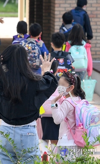 인천을 비롯한 수도권 지역의 유·초·중·고 학생들의 등교가 한달여만에 이뤄진 21일 오전 서구의 한 초등학교 1학년 학부모가 손을 흔들며 배웅하고 있다. 장용준기자