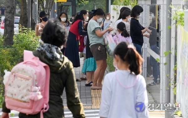 인천을 비롯한 수도권 지역의 유·초·중·고 학생들의 등교가 한달여만에 이뤄진 21일 오전 서구의 한 초등학교 1학년 학부모들이 학생들을 배웅하고 있다. 장용준기자