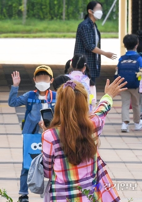 인천을 비롯한 수도권 지역의 유·초·중·고 학생들의 등교가 한달여만에 이뤄진 21일 오전 서구의 한 초등학교 1학년 학부모가 손을 흔들며 배웅하고 있다. 장용준기자