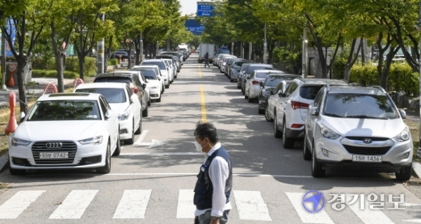 21일 오전 수원시 권선행정타운 내 도로변(한전 서수원지사~경인지방우정청 160여m 구간)에 불법 주정차 차량들이 길게 늘어서 있다.조주현기자