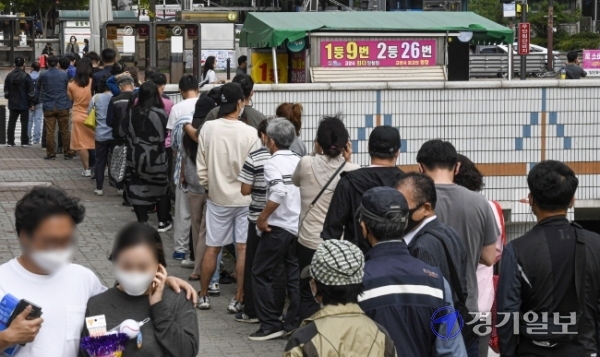 코로나19 장기화로 불황이 계속되는 가운데 지난 3일 오후 고양시 일산동구 한 복권판매점에 일확천금을 꿈꾸는 시민들로 긴 줄이 늘어서 있다. 올 상반기 복권은 2조 6천억원 어치 팔려나가 2005년 이후 최대 규모의 판매를 기록한 것으로 나타났다.조주현기자