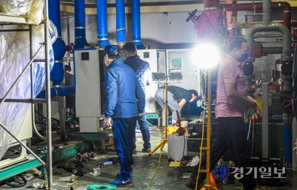 정전 사태가 발생한 수원시 영통구 망포동 A 아파트 기계실에서 10일 오후 관계자들이 펌프 전기시설에 대한 복구 작업을 하고 있다. 이 아파트는 지난 4일 오전 4시께 변전실이 침수, 정전이 발생해 전기와 수도 공급이 중단되면서 장시간 주민들이 불편을 겪고 있다.조주현기자