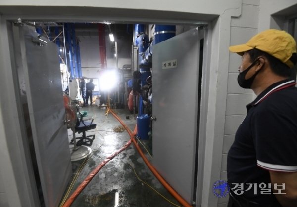 정전 사태가 발생한 수원시 영통구 망포동 A 아파트 기계실에서 10일 오후 관계자들이 펌프 전기시설에 대한 복구 작업을 하고 있다. 이 아파트는 지난 4일 오전 4시께 변전실이 침수, 정전이 발생해 전기와 수도 공급이 중단되면서 장시간 주민들이 불편을 겪고 있다.조주현기자
