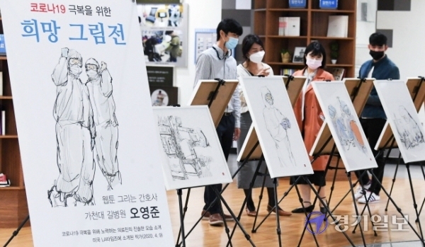 12일 오전 인천시청 중앙홀에서 공무원들이 오영준 길병원 간호사의 '코로나19 극복을 위한 희망 그림전'을 관람하고 있다. 전시작품에는 코로나19 발병초기에 길병원 음압실 병동에서 근무를 하며 스트레스와 애환을 겪는 오간호사의 동료들 모습이 사실적으로 담겨 있다. 장용준기자