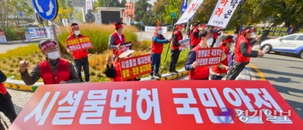 20일 오전 국토교통위원회 국정감사가 열린 경기도청 앞에서 시설물유지관리사업자들이 시설물유지관리업종 폐지를 반대하며 구호를 외치고 있다. 윤원규기자