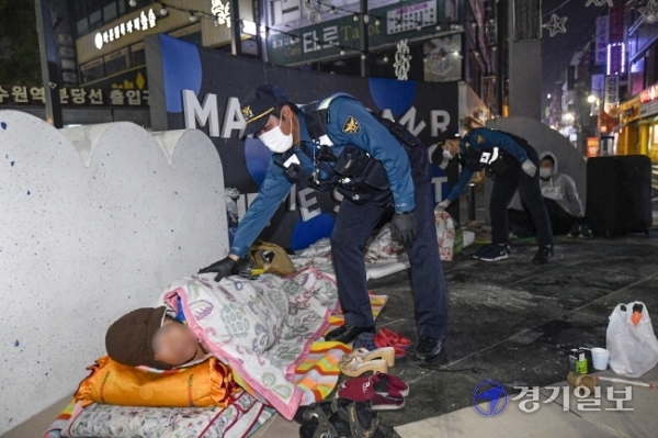 경찰의 날을 하루 앞둔 20일 새벽 수원 매산지구대 순찰3팀 차동진 경장(41) 등이 수원역 로데오거리에서 노숙인들의 안전을 확인하고 있다. 조주현기자<br>